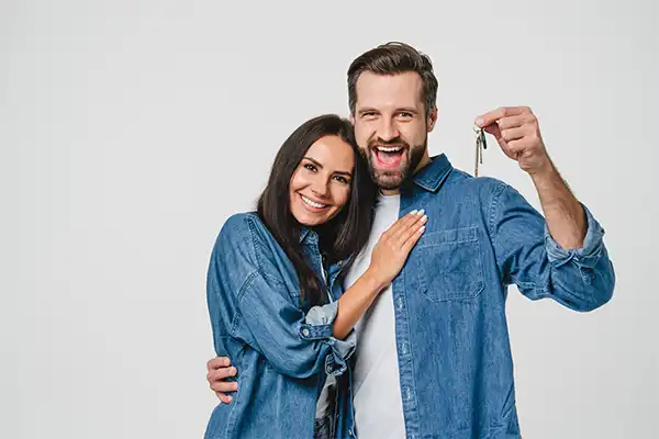 About Our Team happy couple holding keys to new house